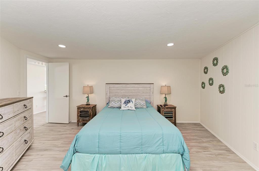 6590 Manasota Key Road Englewood, FL 34223 - Photo 31 of 69 a bedroom with a bed and wooden floor