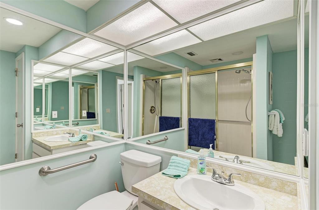 6590 Manasota Key Road Englewood, FL 34223 - Photo 34 of 69 a bathroom with a granite countertop sink toilet a large mirror and shower
