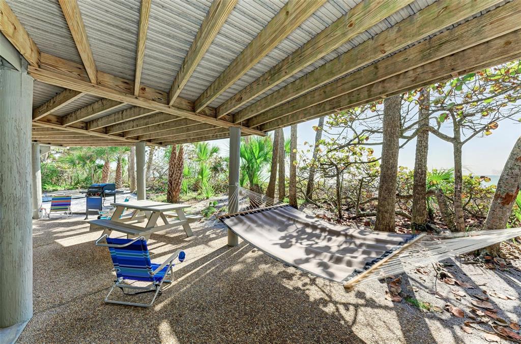 6590 Manasota Key Road Englewood, FL 34223 - Photo 46 of 69 a view of a patio with a table chairs and wooden fence