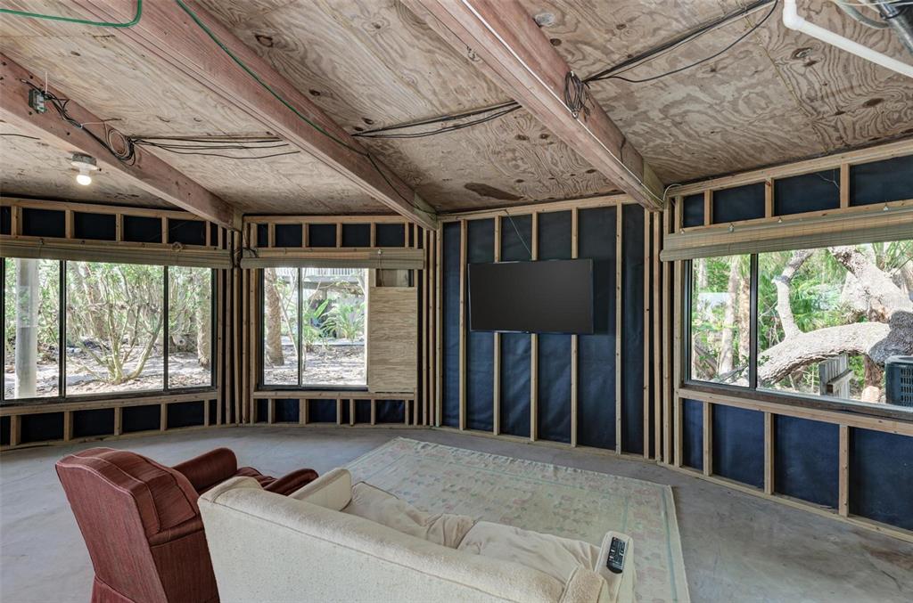 6590 Manasota Key Road Englewood, FL 34223 - Photo 57 of 69 a living room with furniture tv and large windows