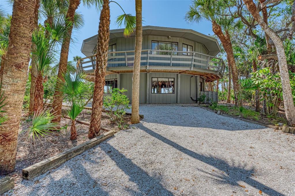 6590 Manasota Key Road Englewood, FL 34223 - Photo 6 of 69 a front view of a house with a yard and trees