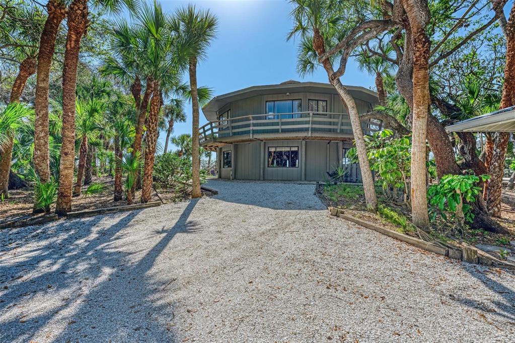 6590 Manasota Key Road Englewood, FL 34223 - Photo 7 of 69 a front view of a house with a garden