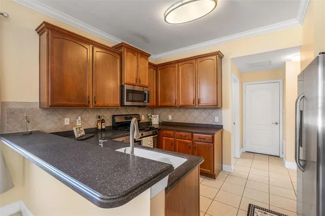 a kitchen with stainless steel appliances granite countertop a sink stove and microwave