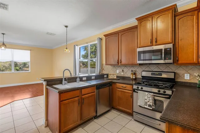 a kitchen with stainless steel appliances granite countertop a sink stove and microwave