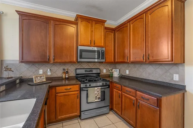 a kitchen with stainless steel appliances granite countertop a sink refrigerator and cabinets