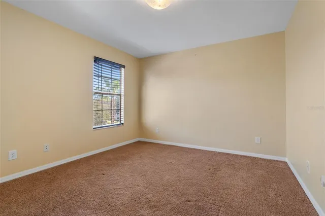 an empty room with windows and a ceiling fan