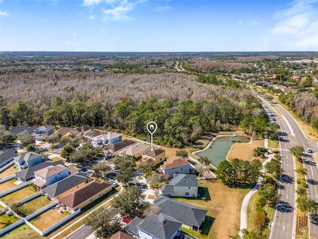 an aerial view of a house with a yard lake and mountain view in back