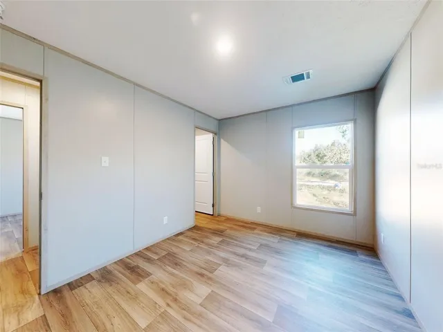 a view of a room with wooden floor a bathroom and bathroom