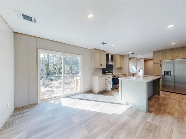 a kitchen with stainless steel appliances granite countertop a sink window and cabinets