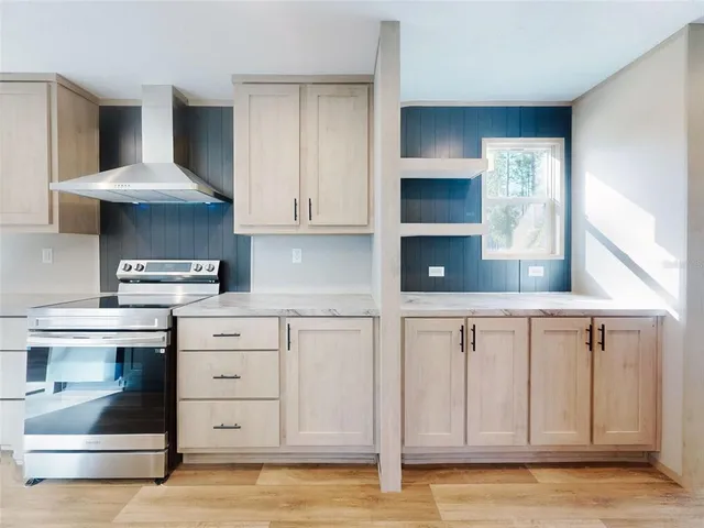 a kitchen with stainless steel appliances granite countertop a sink a stove and a refrigerator