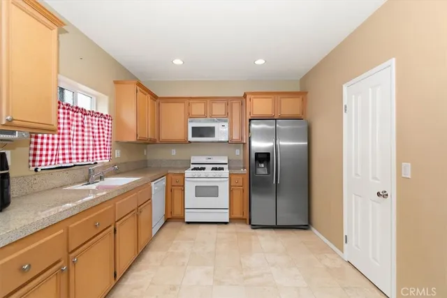 a kitchen with stainless steel appliances granite countertop a refrigerator and a sink
