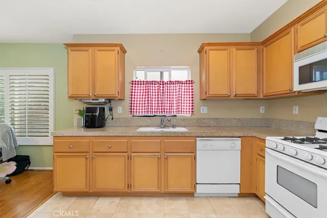 a kitchen with granite countertop white cabinets and white appliances
