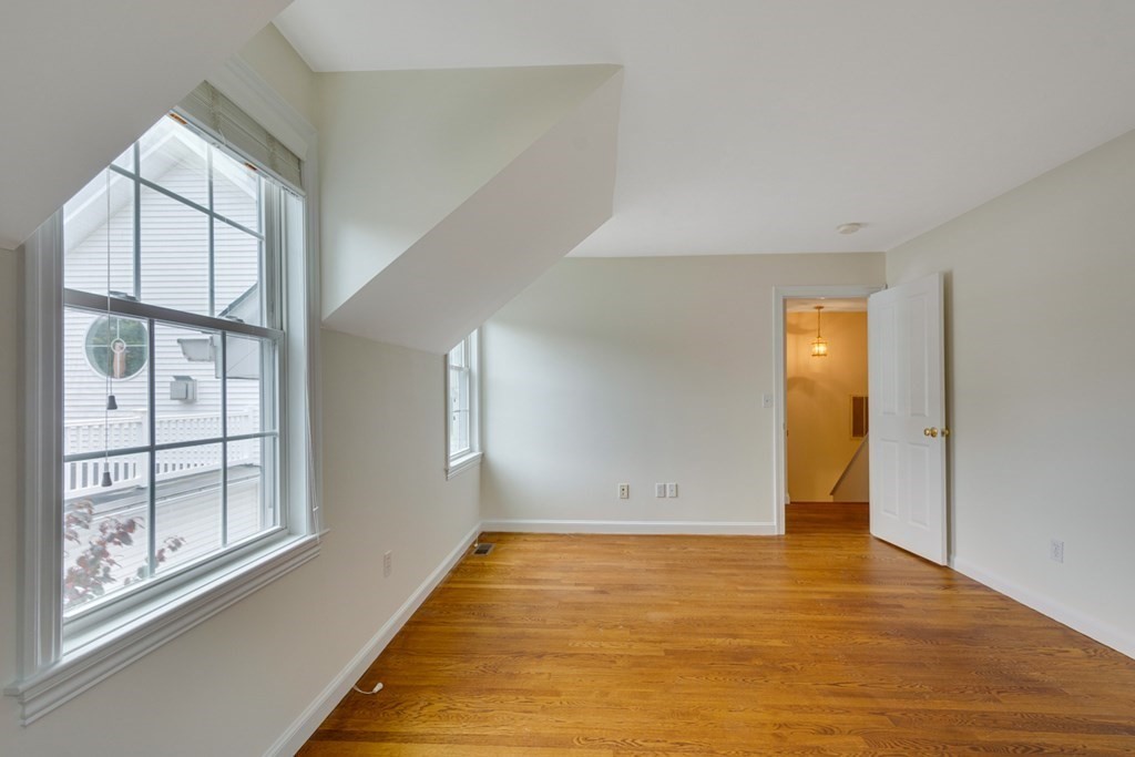 10 Rivard Road, Unit 10 Needham, MA 02492 - Photo 20 of 29 a view of an empty room with window and wooden floor