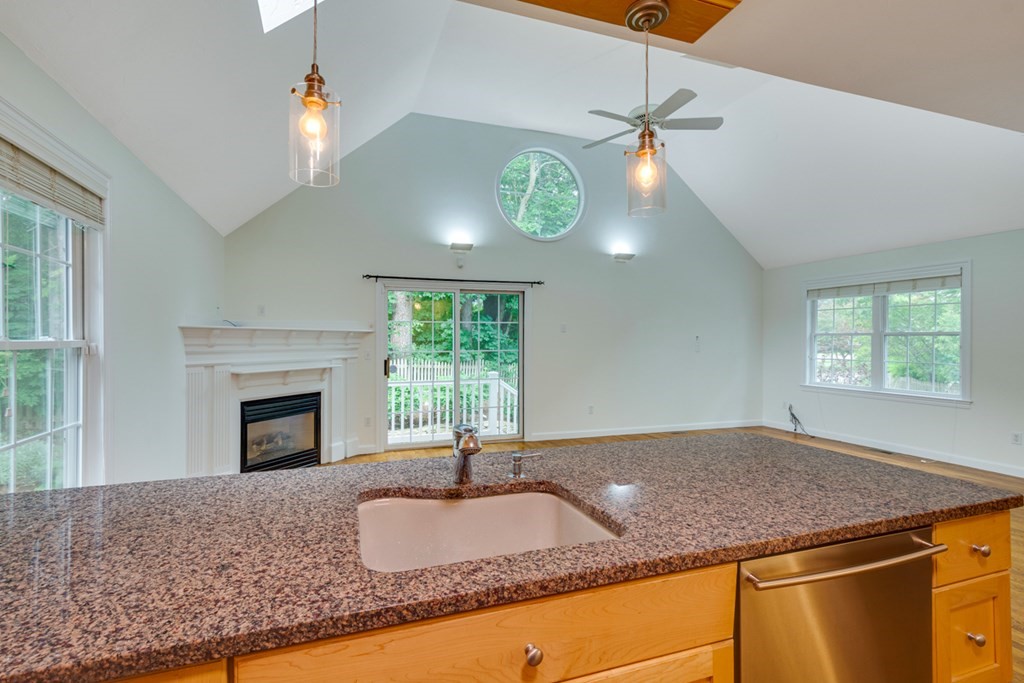 10 Rivard Road, Unit 10 Needham, MA 02492 - Photo 10 of 29 a kitchen with granite countertop a sink a counter top with fireplace and wooden floors