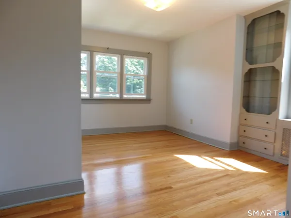 a view of a room with wooden floor and cabinet