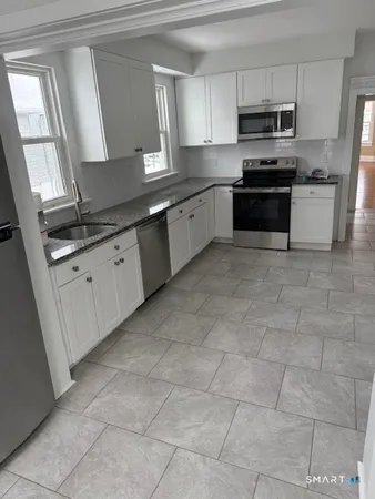 a kitchen with stainless steel appliances granite countertop a sink and a stove