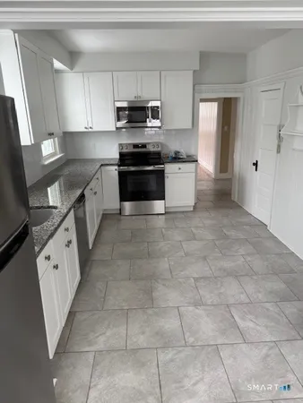 a large kitchen with a stove a sink dishwasher and a refrigerator