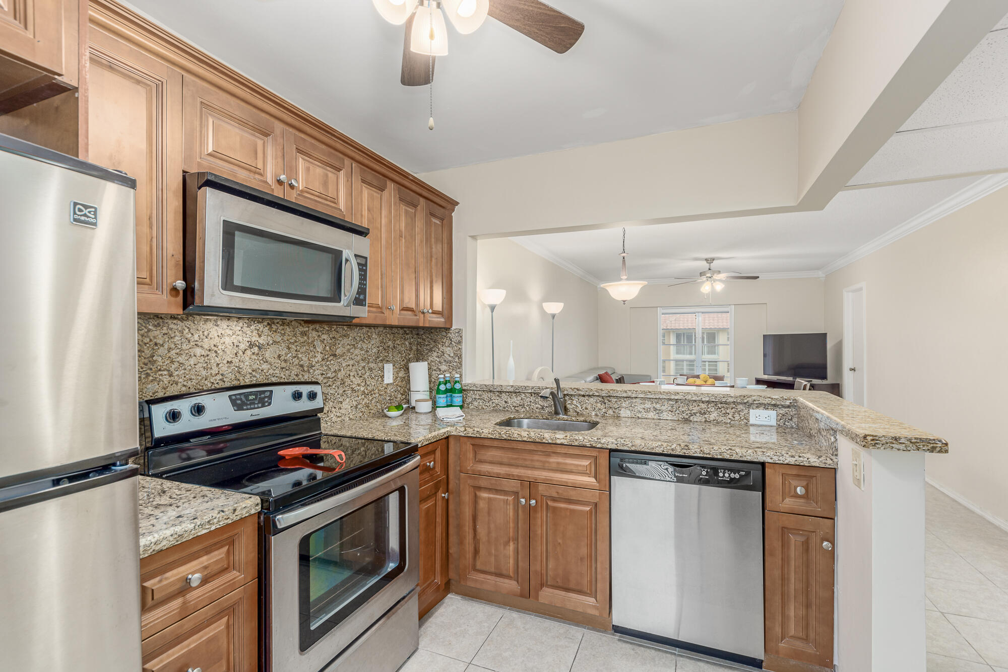 400 Northeast 20th Street, Unit D307 Boca Raton, FL 33431 - Photo 21 of 34 a kitchen with stainless steel appliances granite countertop a stove sink microwave and cabinets