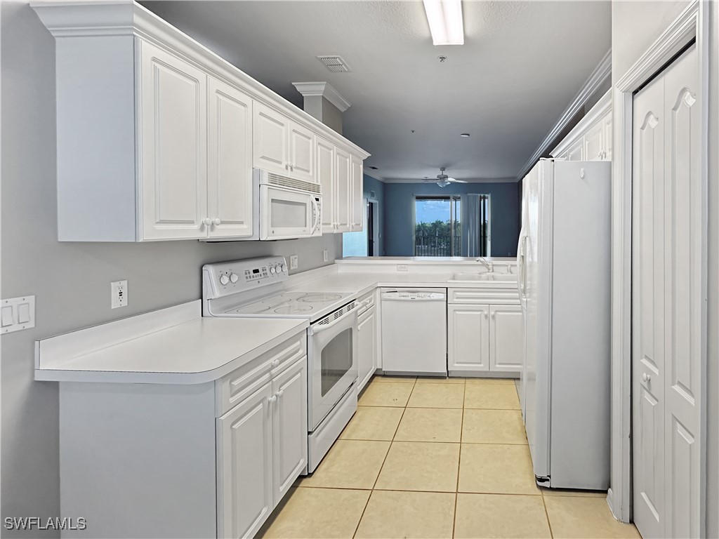 8451 Kingbird Loop, Unit 345 Estero, FL 33967 - Photo 5 of 10 a kitchen with a sink a stove cabinets and a refrigerator