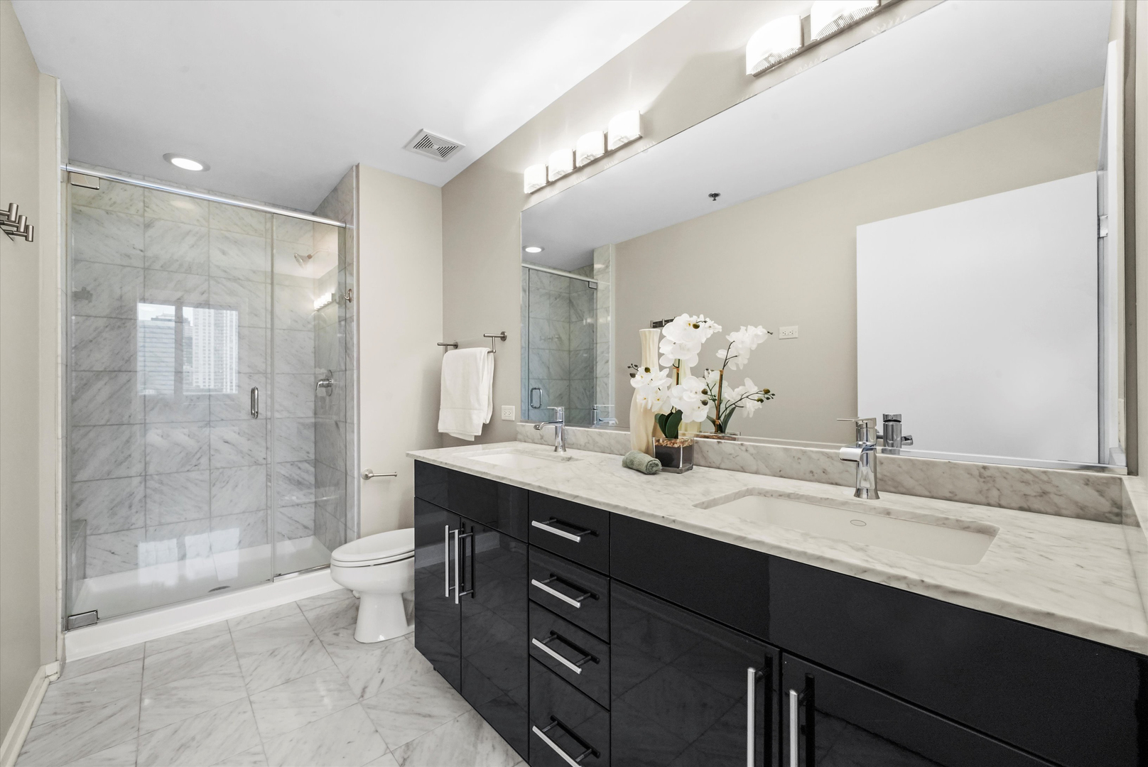 125 South Green Street, Unit 806A Chicago, IL 60607 - Photo 16 of 35 a bathroom with a double vanity sink mirror double shower and a bathtub