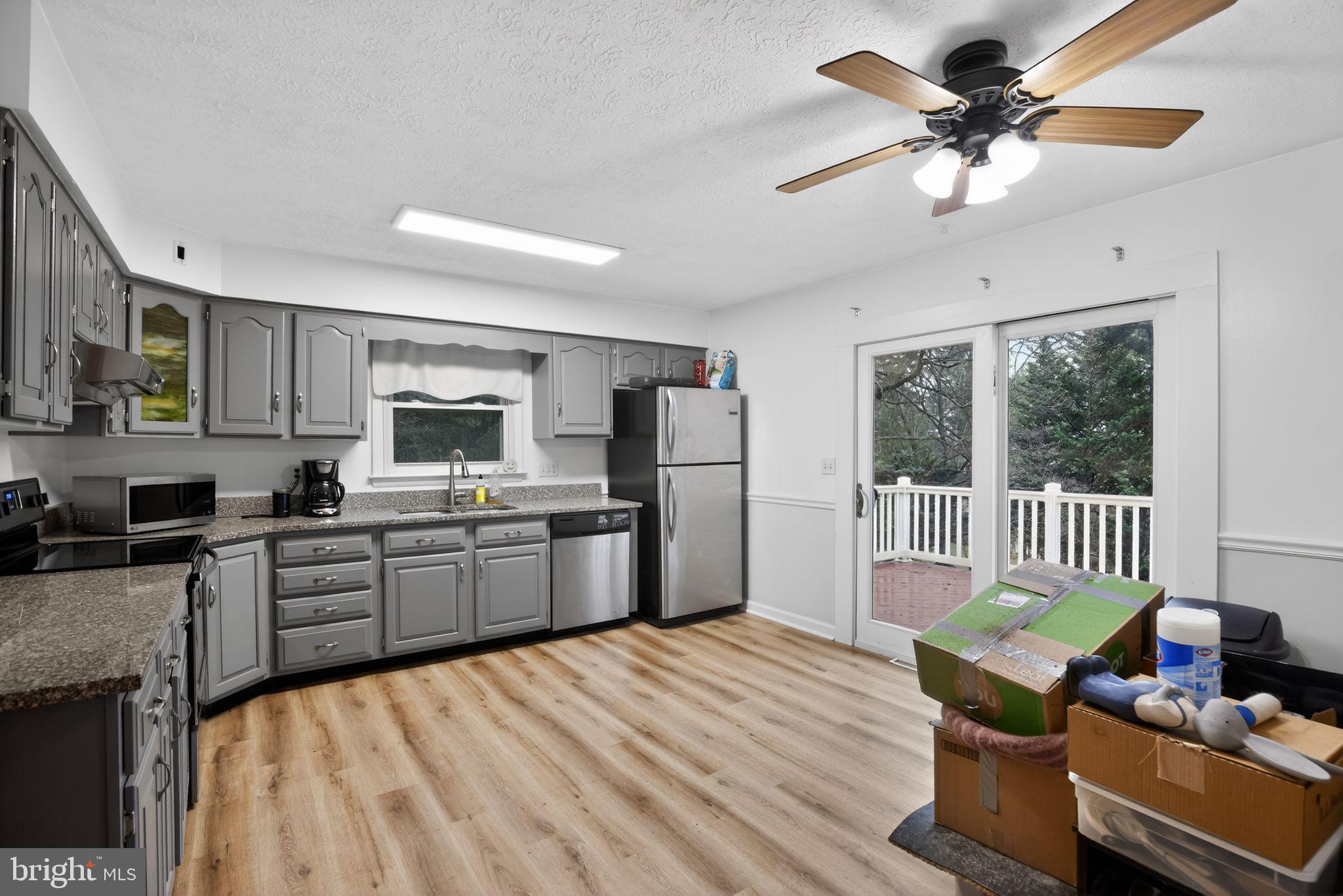 1201 North Tollgate Road Bel Air, MD 21014 - Photo 16 of 41 a large kitchen with stainless steel appliances granite countertop a stove a sink dishwasher a dining table and chairs with wooden floor