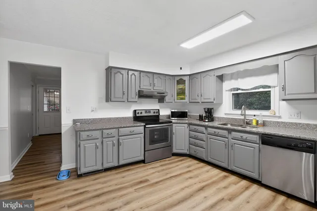 a kitchen with stainless steel appliances granite countertop a sink and cabinets