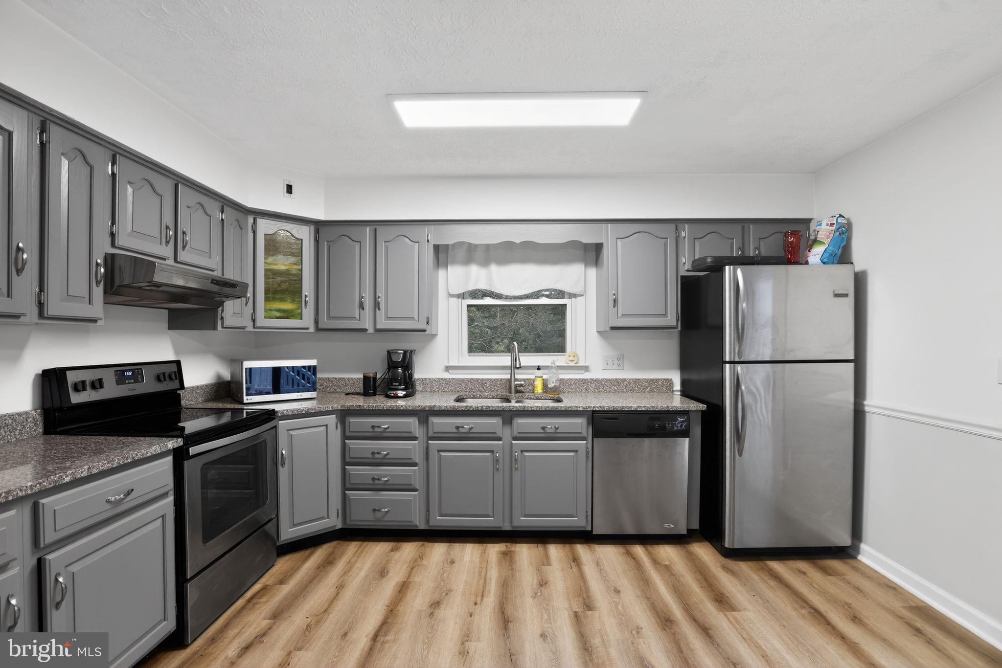 1201 North Tollgate Road Bel Air, MD 21014 - Photo 18 of 41 a kitchen with a sink a refrigerator a microwave and cabinets