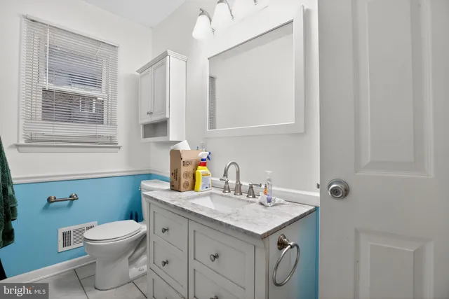 a bathroom with a granite countertop toilet sink and mirror