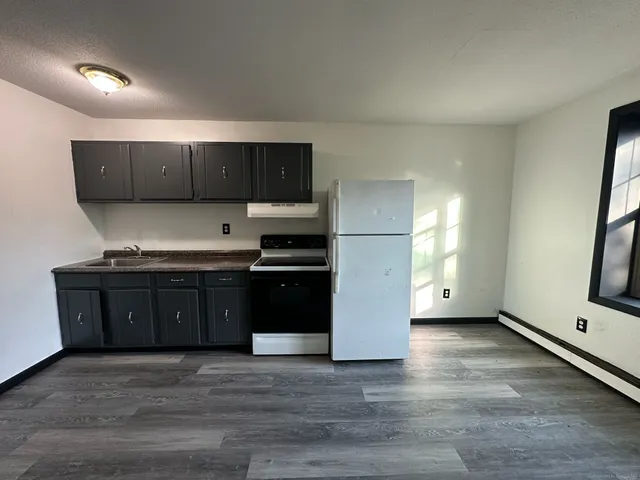 a kitchen with granite countertop a refrigerator and a stove