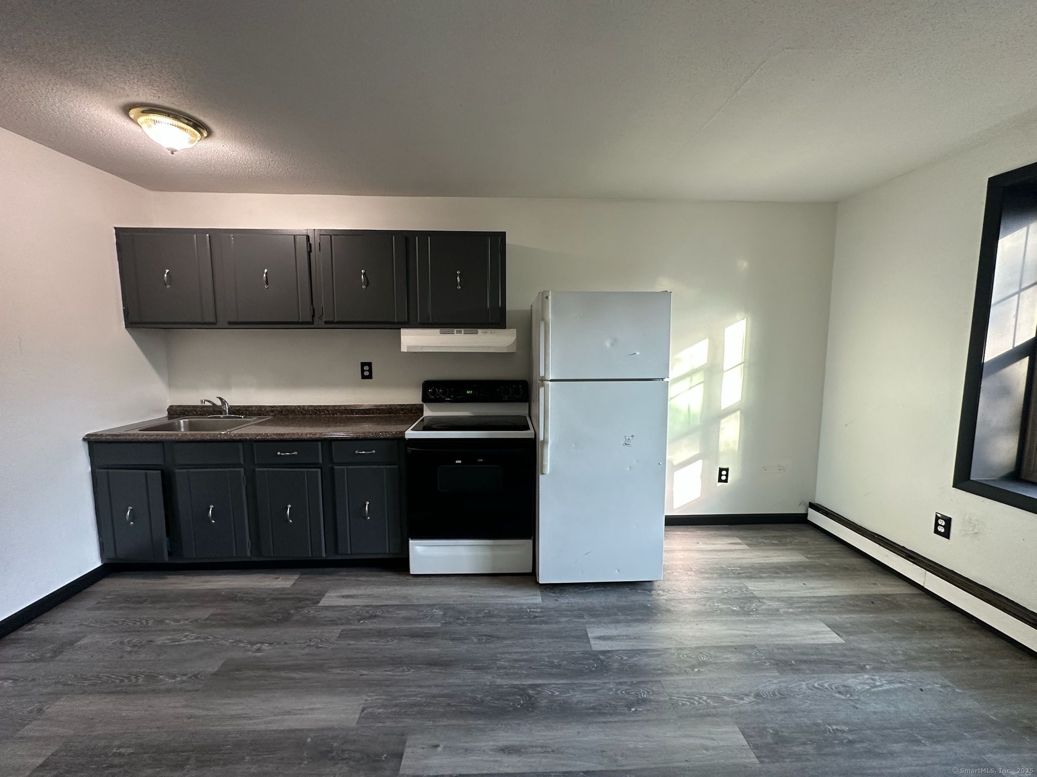a kitchen with granite countertop a refrigerator and a stove