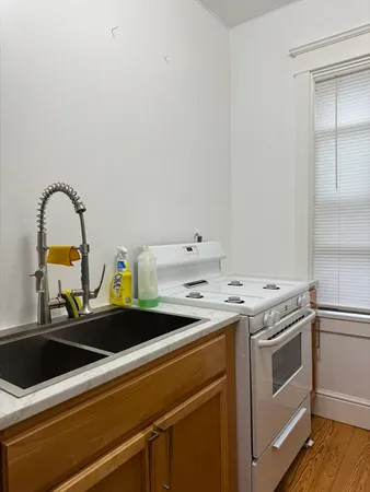 a kitchen with a sink and wooden floor