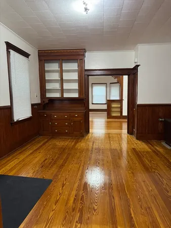 a spacious bedroom with a bed and wooden floor