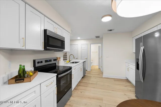 a kitchen with stainless steel appliances granite countertop a refrigerator a stove and a sink