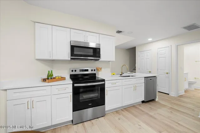 a kitchen with a sink and steel appliances