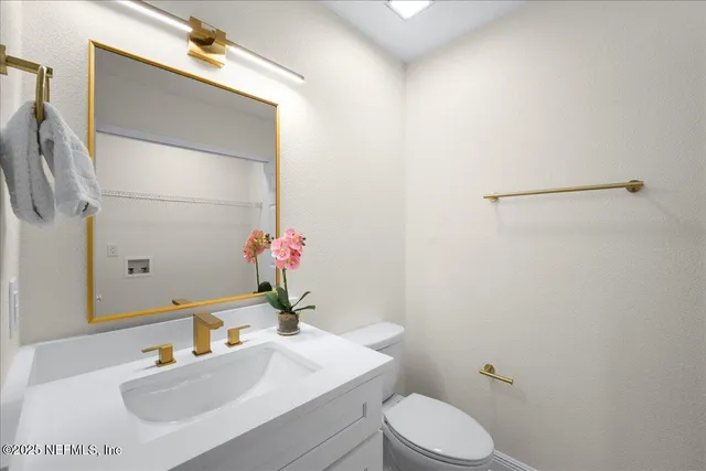 a bathroom with a sink vanity mirror and toilet