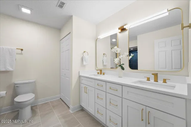 a bathroom with a toilet a sink a mirror and a shower