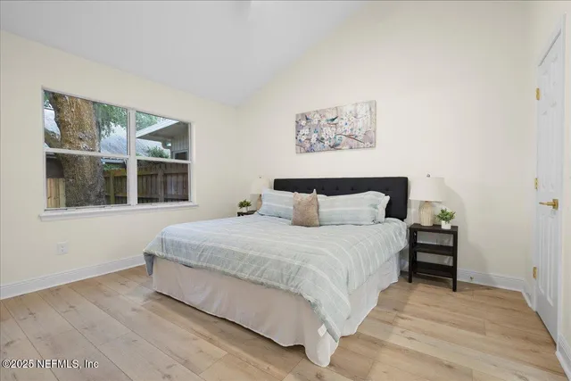 a large bed sitting in a bedroom next to a window