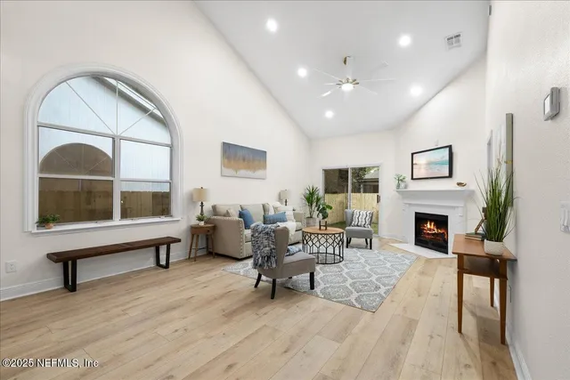 a living room with furniture a fireplace and a large window