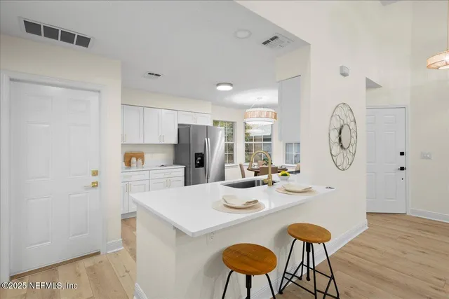 a kitchen with stainless steel appliances a table chairs and a refrigerator