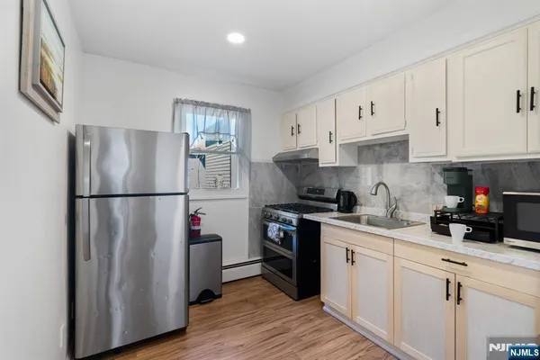a kitchen with appliances a sink and cabinets