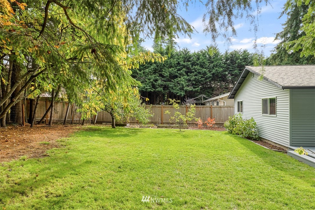 16505 23rd Avenue Southeast Bothell, WA 98012 - Photo 7 of 33 a backyard of a house with plants and large trees