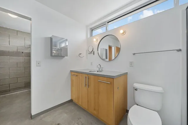 a bathroom with a toilet a sink and a mirror