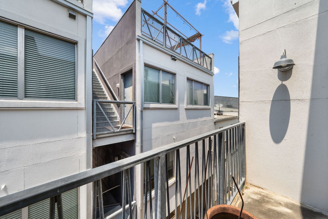 4801 South Congress Avenue, Unit D4 Austin, TX 78745 - Photo 25 of 27 a view of balcony with wooden floor and fence