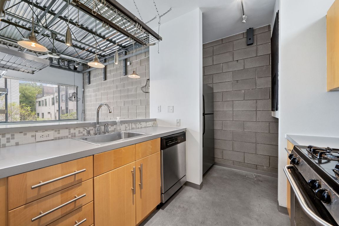 4801 South Congress Avenue, Unit D4 Austin, TX 78745 - Photo 6 of 27 a kitchen with stainless steel appliances a sink stove and cabinets