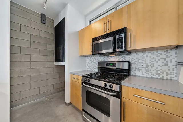 a kitchen with granite countertop cabinets stainless steel appliances and a counter space