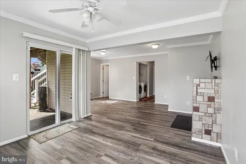 a view of a livingroom with wooden floor and a ceiling fan
