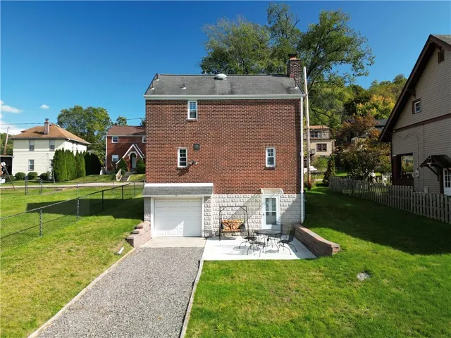 an aerial view of a house with a yard and large trees