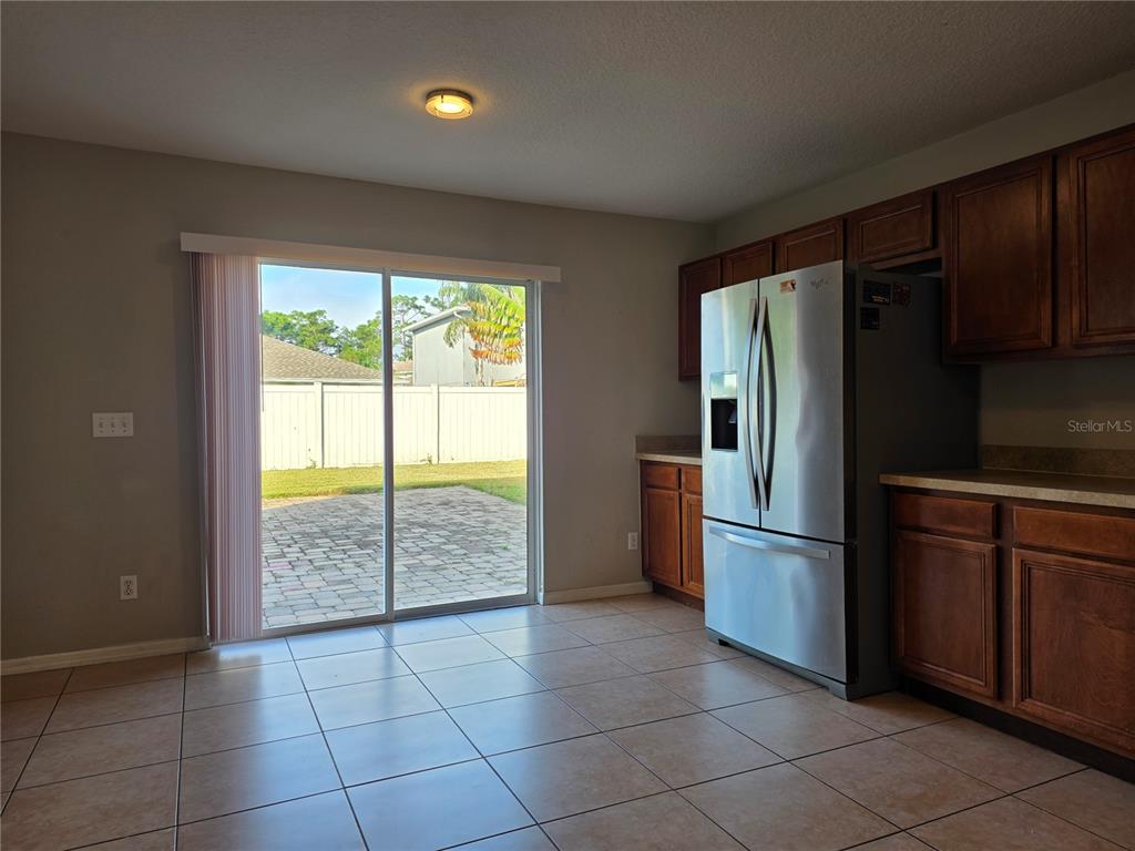 1645 Algonkin Loop Orlando, FL 32828 - Photo 12 of 37 a kitchen with a refrigerator a microwave and cabinets