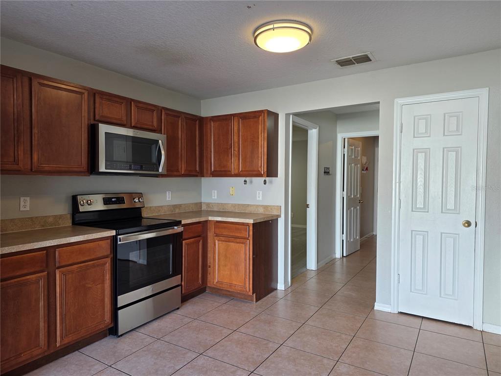 1645 Algonkin Loop Orlando, FL 32828 - Photo 13 of 37 a kitchen with stainless steel appliances granite countertop a stove top oven a sink dishwasher and a microwave oven on the blue kitchen countertops