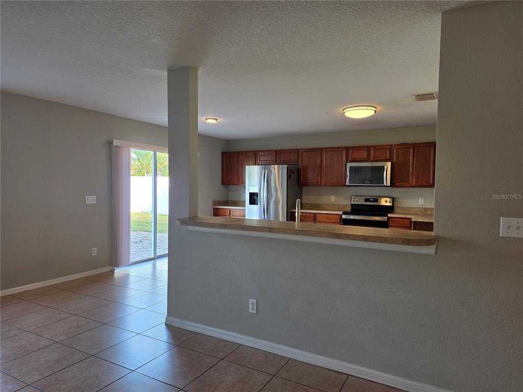 1645 Algonkin Loop Orlando, FL 32828 - Photo 8 of 37 a kitchen with stainless steel appliances a refrigerator and a stove top oven